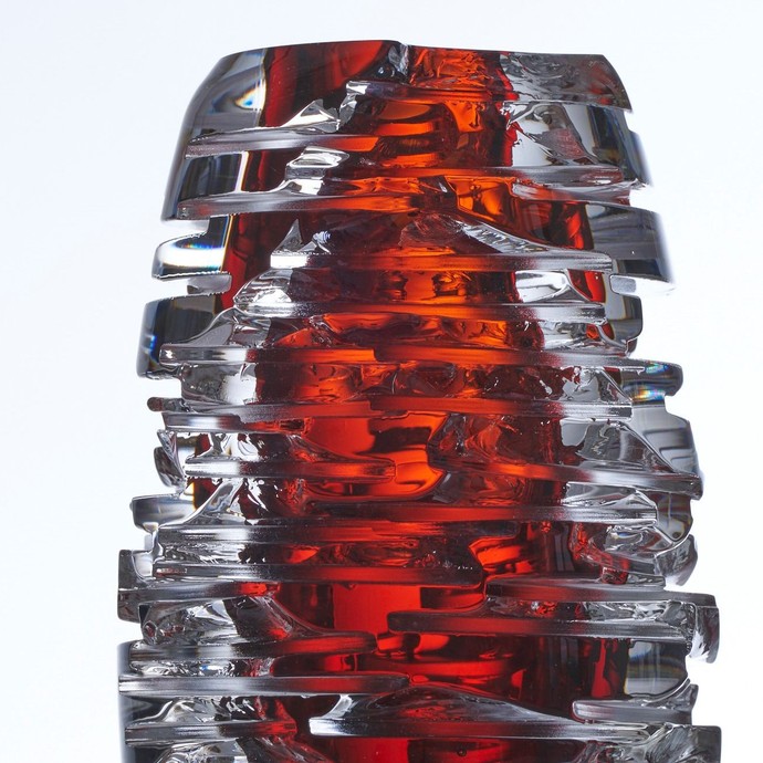 "Birindar (Verletzt)" von Rasit Rejwan Toplu. Längliches Glasobjekt, von schmalen Einschnitten durchzogen, mit rotem Kern. (vergrößerte Bildansicht wird geöffnet)