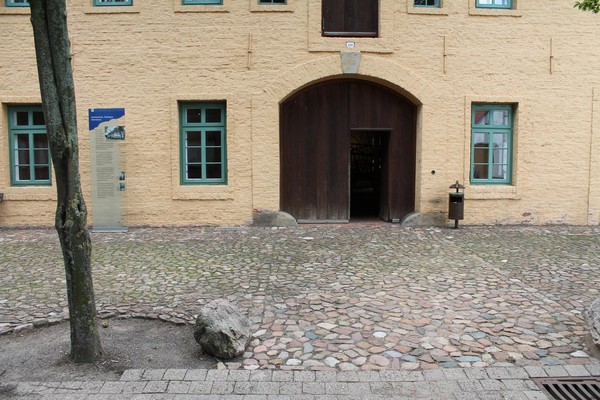 Vor dem Eingang der Korbflechterei ist Kopfsteinpflaster verlegt.