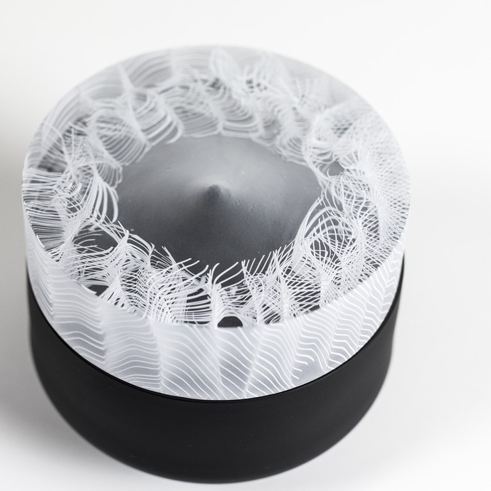 "Urn IV" von Helmi Remes. Schwarzes rundes Glasobjekt, am oberen Rand weiß gemustert abschließend. (vergrößerte Bildansicht wird geöffnet)