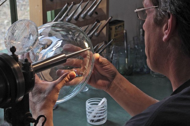 Ein Graveur graviert ein Glasobjekt