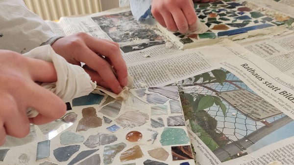 Zwei Kinder stellen Mosaikarbeiten her